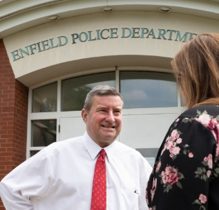 Senator Kissel in front of the Enfield Police Department building speaking to a constituent